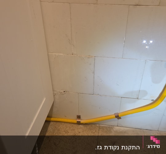 צינור גז צהוב מחובר לקיר עם שסתום